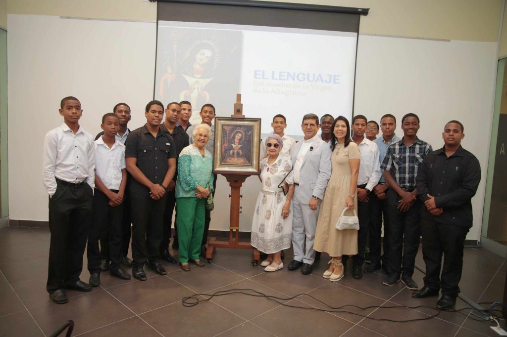 Miguel Óscar Valdez posa con jóvenes y otros participantes de la conferencia alrededor de una reproducción del cuadro de la Virgen de la Altagracia.